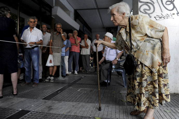 A pensioner (R) arrives at a National Bank branch to receive part of her pension at the city of Thessaloniki, Greece (Reuters/Alexandros Avramidis)