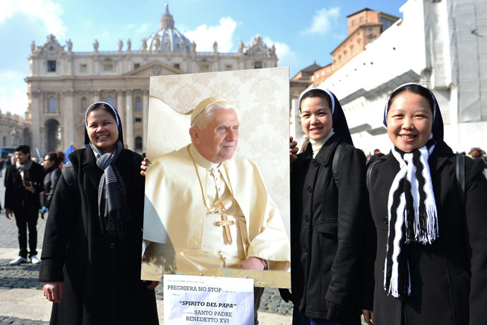 Asian nuns hold a portrait of Pope Benedict XVI on St Peter's square after the Angelus prayer led by Pope Benedict XVI from the window of his appartments.(AFP Photo / Gabriel Bouys)