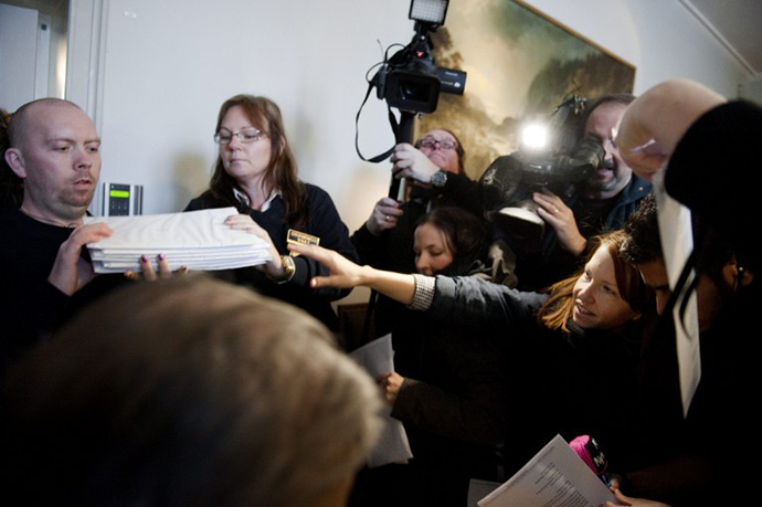 Reporters get a copy of the Svea Appeals Court verdict in the Pirate Bay case in Stockholm on November 26, 2010. (AFP Photo / Jessica Gow)