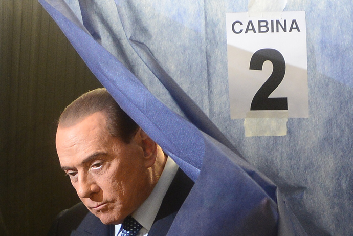 Italian former Prime Minister Silvio Berlusconi leaves the voting booth before casting his ballot at a polling station on February 24, 2013 in Milan (AFP Photo / Olivier Morin)