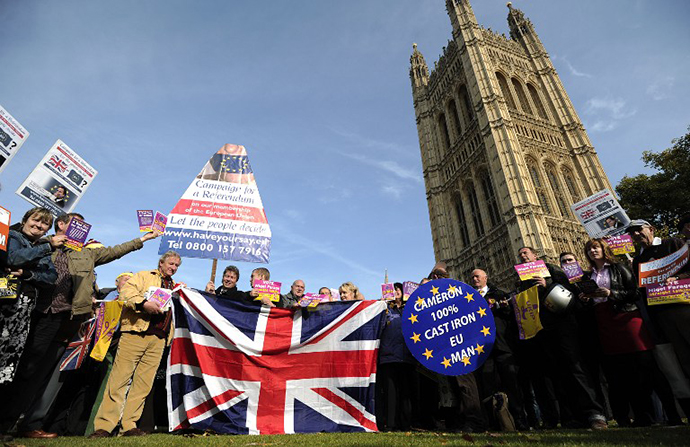United Kingdom Independence Party (UKIP) supporters hold Union Jack flags and placards as they take part in a demonstration outside the Houses of Parliament in central London on October 24, 2011. (AFP Photo / Carl Court)