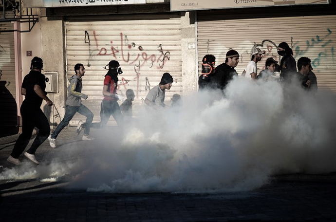 Anti-regime Bahraini protestors run for cover from tear gas and bird shots fired by riot police during clashes on February 22, 2013. (AFP Photo / MohammedAl-Shaikh)