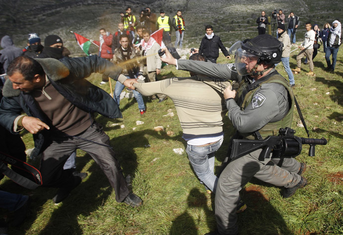 An Israeli border police officer uses pepper spray to disperse Palestinian activists after the group set up tents and makeshift structures in protest against a nearby Jewish settlement in the West Bank village of Burin, south of Nablus (Reuters/Mohamad Torokman)