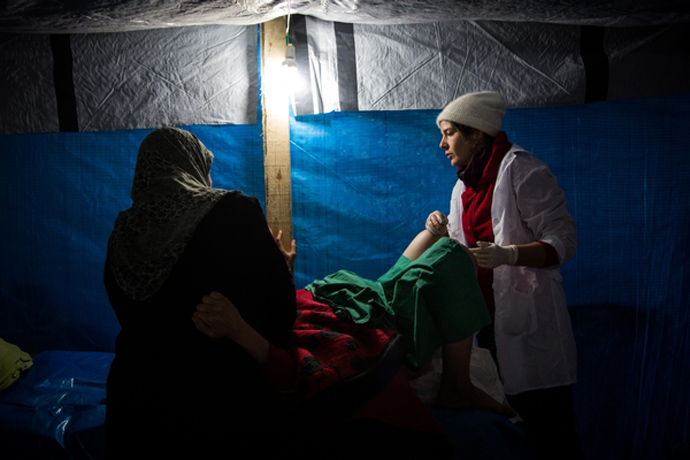 Midwife Cathy Janssens calms and assists patient Raida Dumyati as she attempts to deliver her baby by natural means at the MSF hospital in Northern Syria (photo by Nicole Tung)