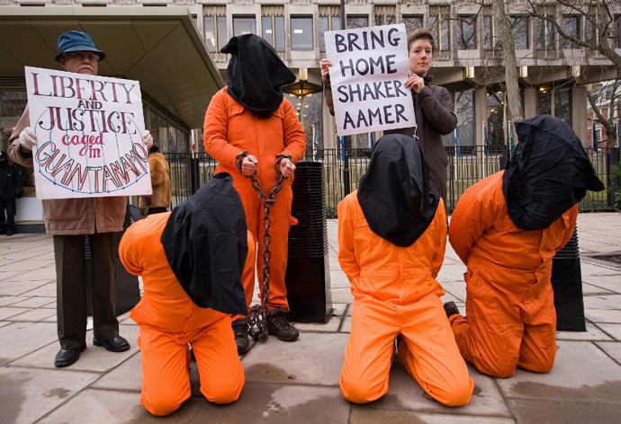 A protestor holds up a sign calling for the release of Shaker Aamer from the Guantanamo prison during a demonstration in central London, on January 11, 2010. (AFP Photo / Leon Neal)
