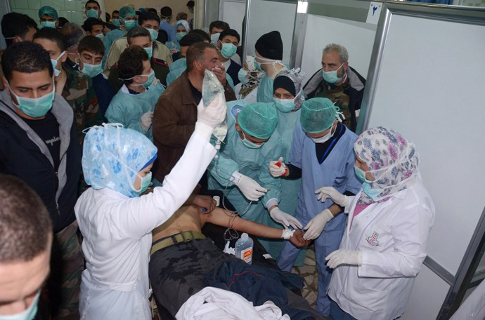Medics and other masked people attend to a man at a hospital in Khan al-Assal in the northern Aleppo province, as Syria's government accused rebel forces of using chemical weapons for the first time on March 19, 2013. (AFP Photo / SANA)