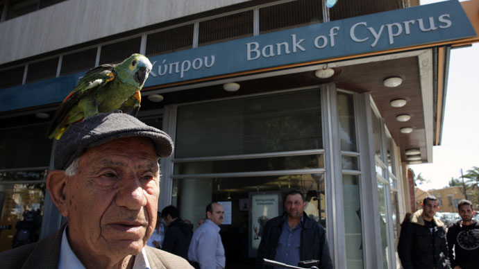 A man with a parrot on his head is seen outside a Bank of Cyprus branch in the Cypriot capital, Nicosia, on March 28, 2013.(AFP Photo / Yiannis Kourtoglou)