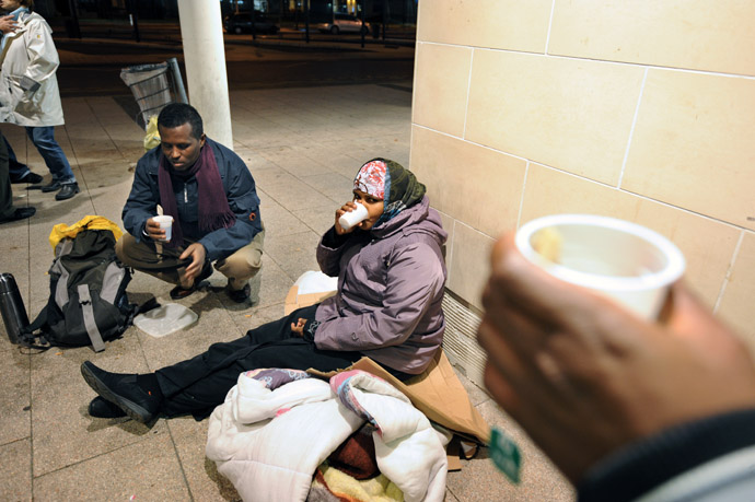 Migrants seeking asylum in France, hold drinks as they prepare to spend a night outside the railway station in Angers, centre France. (AFP Photo)