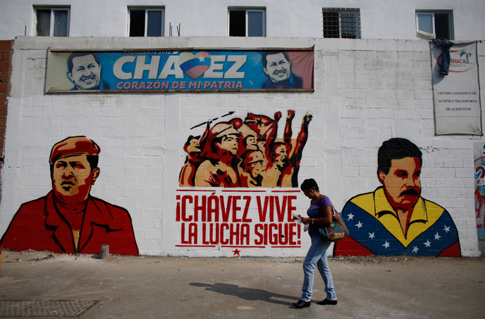 A woman walks past a mural depicting Venezuela's acting President and presidential candidate Nicolas Maduro (R) and Venezuela's late President Hugo Chavez in Caracas April 12, 2013 (Reuters / Tomas Bravo)