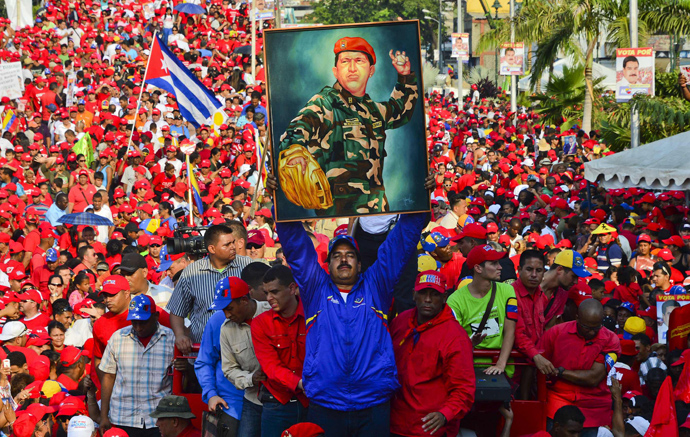 Venezuela's acting President Nicolas Maduro holds a picture of the late president Hugo Chavez during a campaign rally in Catia la mar, state of Vargas (AFP Photo / Luis Acosta) 