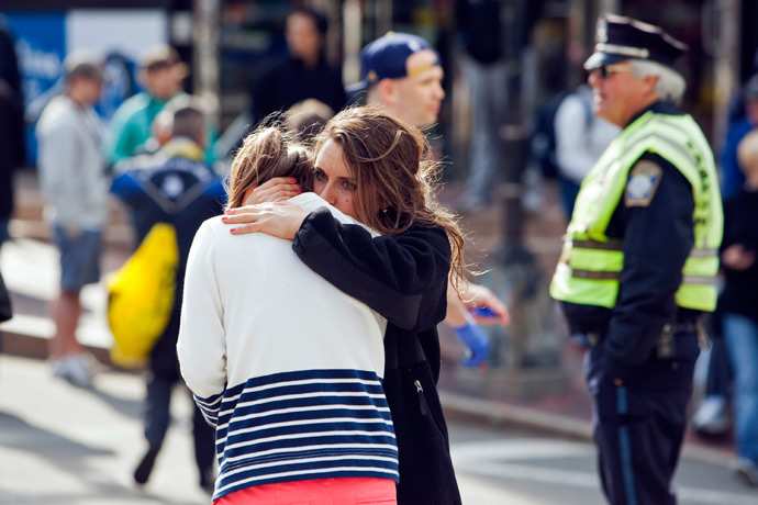 A woman comforts another, who appears to have suffered an injury to her hand, after explosions interrupted the 117th Boston Marathon in Boston, Massachusetts April 15, 2013 (Reuters / Dominick Reuter)