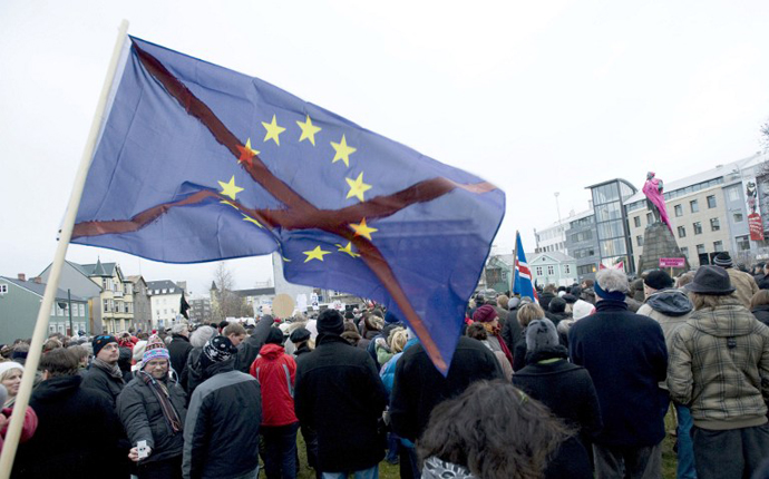 A man holding a crossed European flag, demonstrates in central Reykjavik during the weekly protest on November 22, 2008. (AFP Photo / Halldor Kolbeins)