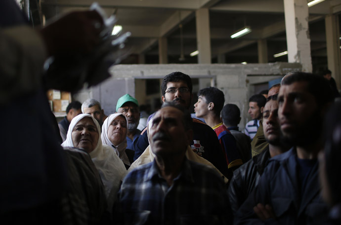 Palestinians wait to receive food supplies inside a United Nations food distribution centre in Gaza City April 10, 2013. (Reuters)