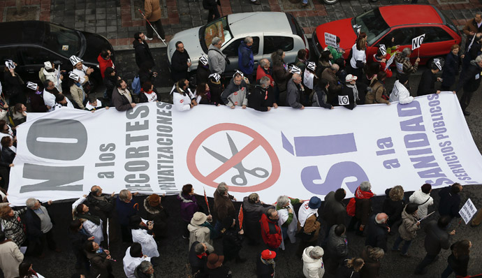 Health workers and supporters carry a banner reading: "No to budget cuts and privatizations, Yes to public health system and services" during a protest against the Madrid regional government's Health Sustainability Plan (Reuters/Juan Medina)