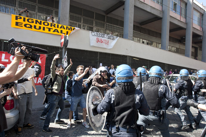  Demonstrators (L) face riot policemen as they try to enter the offices of Equitalia, Italy's tax collection agency during a protest against the government's austerity measures and the wave of suicide committed by businessmen because of the crisis inin Naples. (AFP Photo)