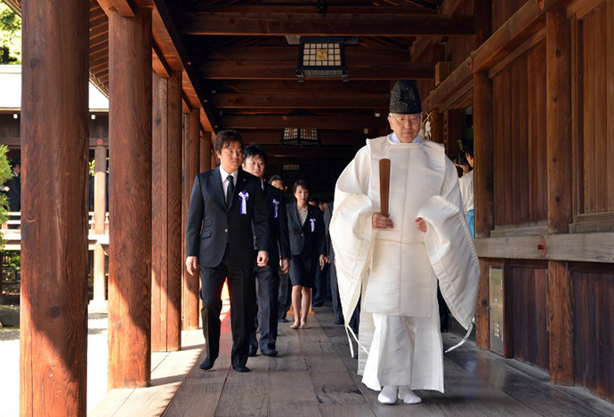 A Shinto priest (R) leads a group of Japanese lawmakers after they offered prayers for the country's war dead at the controversial Yasukuni Shrine in Tokyo on the occasion of the shrine's spring festival on April 23, 2013. (AFP Photo / Yoshikazu Tsuno)