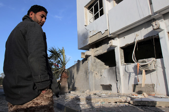  Libyan security forces and bystanders walk outside a damaged police station on April 27, 2013 in Benghazi. (AFP Photo)
