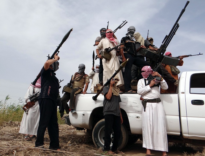 Iraqi armed tribesmen pose for a picture on the back of a truck in a road north of Ramadi, on May 18, 2013 (AFP PHOTO/AZHAR SHALLAL)