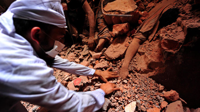 A rescue worker tries to find the remains of the garment workers, who died inside the rubble of the collapsed Rana Plaza building, in Savar, 30 km (19 miles) outside Dhaka April 25, 2013.(Reuters / Stringer)