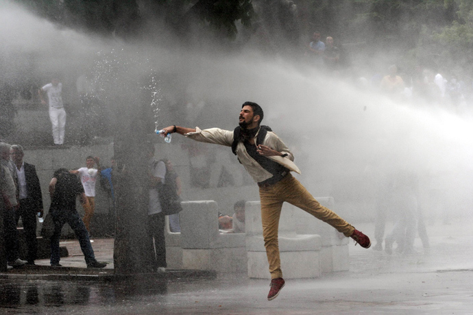 A protester faces a police water canon during clashes with riot police at a demonstration in Ankara on June 16, 2013 (AFP Photo / Adem Altan)