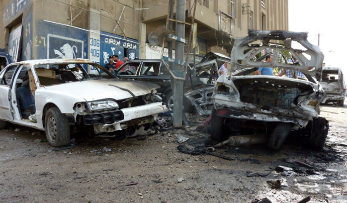 Destroyed cars sit at the site of a blast in Baghdad on May 30, 2013. (AFP Photo / Ali Al-Saadi)