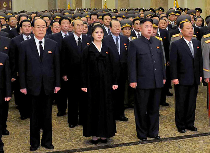 North Korean leader Kim Jong Un (centre R, front), accompanied by his wife Ro Sol Ju (centre L, front) and senior officials of the party and North Korean Army paying respect to late leader Kim Jong Il at the Kumsusan Palace in Pyongyang for the first anniversary of his death (AFP Photo / KCNA via KNS)
