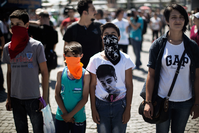 A woman and three children stand on the flashpoint Taksim square in Istanbul on June 18, 2013 during a wave of new alternative protests (AFP Photo / Marco Longari) 