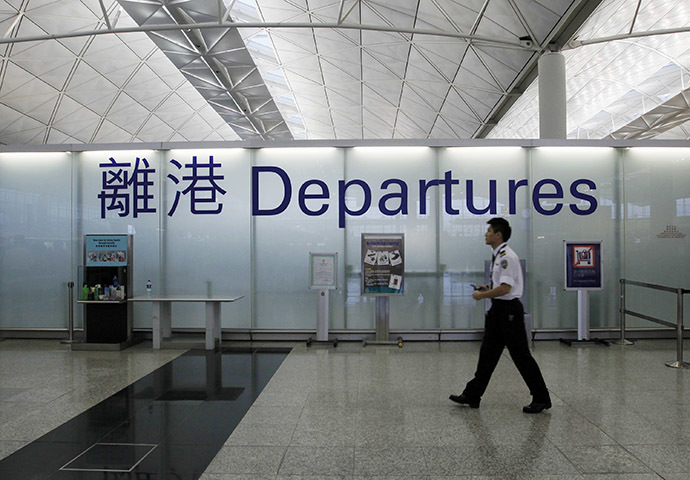 An airport security guard walks past a sign at the departure hall of Hong Kong Airport June 23, 2013. Edward Snowden, a former contractor for the U.S. National Security Agency, charged by the United States with espionage, was allowed to leave Hong Kong on Sunday, his final destination as yet unknown, because a U.S. request to have him arrested did not comply with the law, the Hong Kong government said. (Reuters / Bobby Yip)