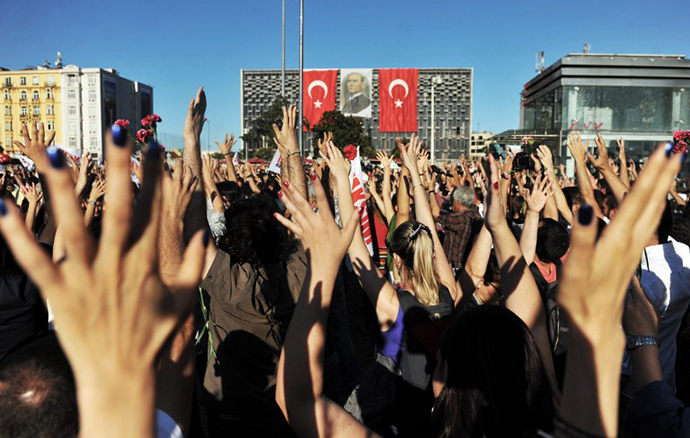 Protesters raise their hands as they gather on Taksim square during the clash between riot police and protestors in Istanbul on June 22, 2013. (AFP Photo / Ozan Kose)