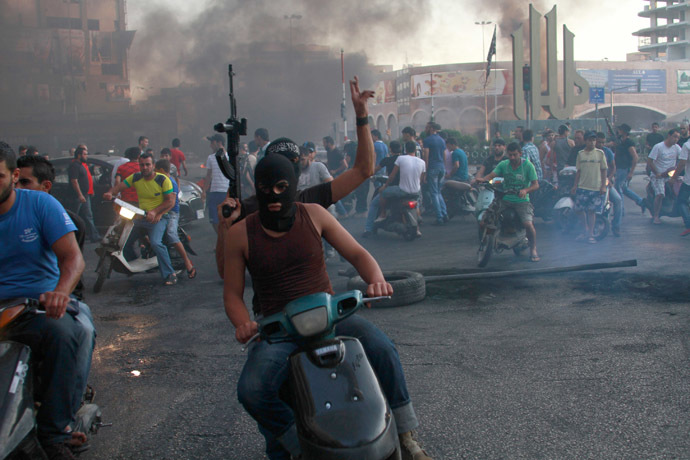 Sunni Muslim gunmen roam the streets and block roads with burning tires, expressing their solidarity with Salafist leader Ahmad al-Assir in Tripoli, northern Lebanon, June 23, 2013. (Reuters)