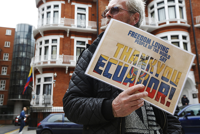 A supporter of Edward Snowden holds a sign outside the Embassy of Ecuador in London (Reuters / Luke MacGregor)