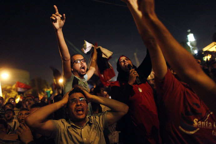 Egyptian protesters calling for the ouster of President Mohamed Morsi react as they watch his speech on a screen in a street leading to presidential palace early in Cairo on July 3, 2013.(AFP Photo / Mahmud Khaled)
