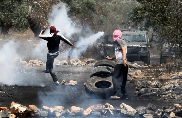 A Palestinian protester kicks back a tear gas canister fired by Israeli security forces as clashes broke out during a demonstration against the expropriation of Palestinian land by Israel in the village of Kfar Qaddum, near the occupied West Bank city of Nablus, on June 16, 2013 (AFP Photo / Jaafar Ashtiyeh) 