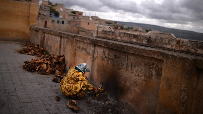 A Syrian Kurdish refugee from the majority-Kurdish Sheikh Maqsud district of the northern Syrian city of Aleppo, prepares a tea in a yard next a school used as a refugee camp in the northern city of Afrin on April 9, 2013. (AFP Photo / Dimitar Dilkoff)