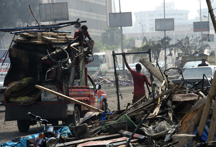 Egyptian scrap metal collectors collect items from the remains of the destroyed camp of ousted Mohammed Morsi supporters outside Rabaa al-Adawiya mosque on August 15, 2013 in Cairo, Egypt (AFP Photo / Khaled Desouki)