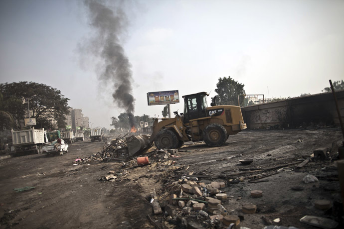 A tractor clears the debris at Rabaa al-Adawiya square in Cairo on August 15, 2013, as smoke billows in the background, following a crackdown on the protest camps of supporters of Egypt's ousted Islamist leader Mohamed Morsi the previous day. (AFP Photo)