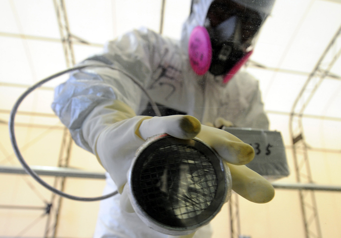 A worker checks radiation levels on the window of a bus during a media tour at Japan's Fukushima Dai-ichi nuclear plant (AFP Photo / Pool / Toshifumi Kitamura) 