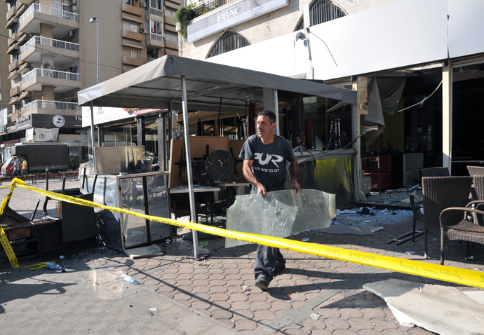 A Lebanese removes debris in a restaurant that was damaged in a bombing outside Al-Salam mosque in the northern city of Tripoli on August 24, 2013 (AFP Photo / Ibrahim Chalhoub)
