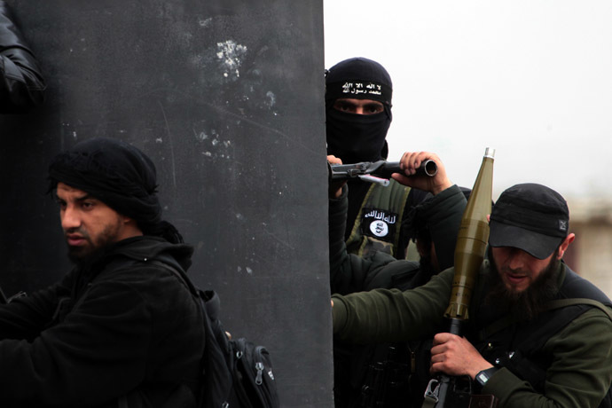 A Turkish fighter of the jihadist group Al-Nusra Front, bearing the flag of Al-Qaeda on his jacket (C-back), holds position with fellow comrades on April 4, 2013 in the Syrian village of Aziza, on the southern outskirts of Aleppo. (AFP Photo)