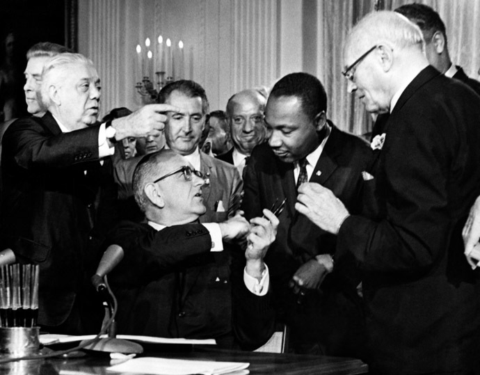 US President Lyndon B. Johnson hands a pent to the Rev. Martin Luther King (2nd-R) after signing the historic Civil Rights Bill in the East Room of the White House, in Washington, D.C., 02 July 1964. (AFP Photo)