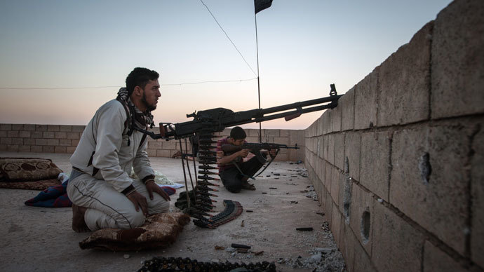 Members of the Islamic Kurdish Front aim their weapons at a position of fellow Kurdish fighters from the Committees for the Protection of the Kurdish People (YPG) during clashes with the militia, reportedly set up to protect the Kurdish areas in Syria from opposing forces, on the outskirts of the northern Syrian city of Raqqa, on August 23, 2013.(AFP Photo / Alice Martins)