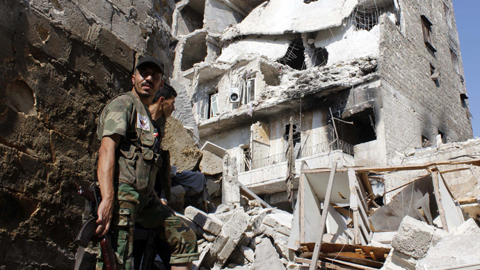 Free Syrian Army fighters stand in front of buildings damaged by what activists said was shelling by forces loyal to Syria's President Bashar al-Assad in the old city of Aleppo September 2, 2013. (Reuters/Molhem Barakat)