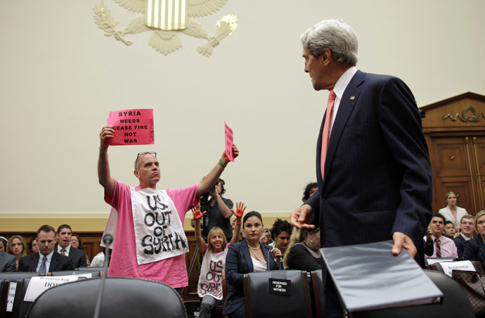 Members of CodePink, Tighe Barry (L) and Medea Benjamin (2nd L) protest as U.S. Secretary of State John Kerry (R) arrives at a hearing on "Syria: Weighing the Obama Administration's Response" before the House Foreign Affairs Committee September 4, 2013 on Capitol Hill in Washington, DC. (Alex Wong/Getty Images/AFP )