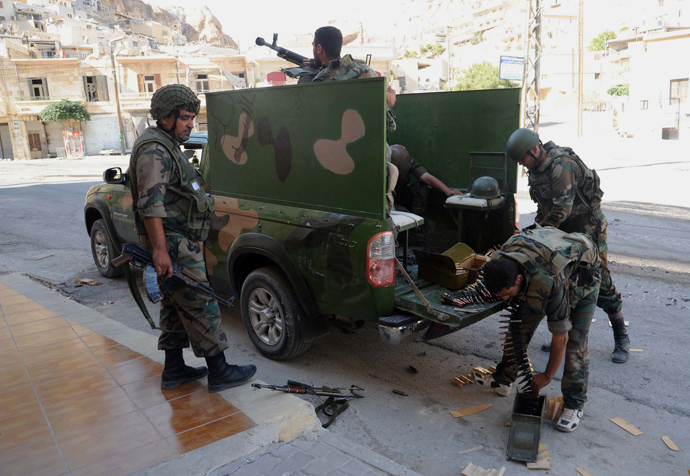 Syrian army forces load a machine gun mounted at the back of a vehicle in the Syrian Christian town of Maaloula on Septamber 7, 2013 (AFP Photo / Str)
