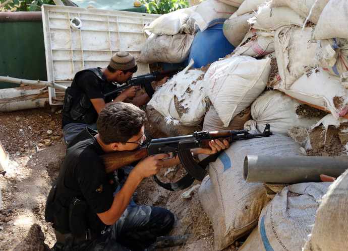 Free Syrian Army fighters take up positions behind piled sandbags as they aim their weapons in the eastern al-Ghouta, near Damascus September 8, 2013. Picture taken September 8, 2013. (Reuters/Msallam Abd Albaset) 