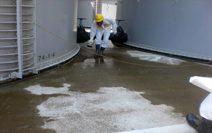 This handout picture taken by Tokyo Electric Power Co (TEPCO) on August 22, 2013 shows a TEPCO worker checking radiation levelS around a contaminated water tank at TEPCO's Fukushima Dai-ichi nuclear power plant at Okuma town in Fukushima prefecture. (AFP/TEPCO)