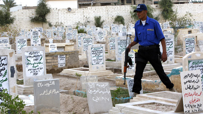 An Iraqi security officer walks past headstones in the "Martyr's Cemetery" in the city of Fallujah.(AFP Photo / Ali Al-Saadi)