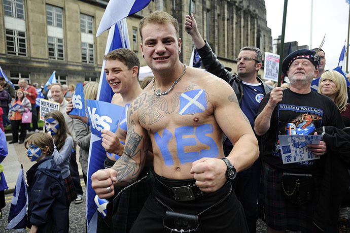 A pro-independence supporter with a Saltire flag and a "Yes" written on his body joins a march and rally in Edinburgh on September 21, 2013 in support of a yes vote in the Scottish Referendum to be held in September 2014. (AFP Photo / Andy Buchanan)