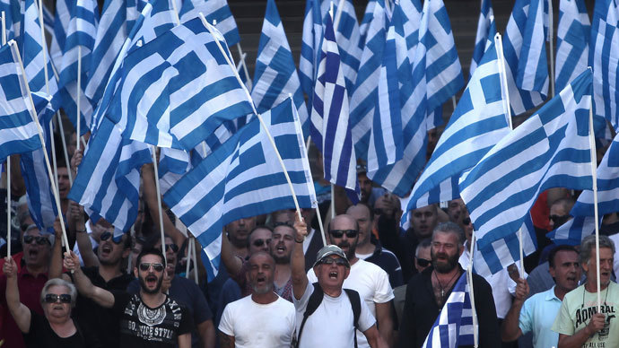 Supporters of the extreme far-right Golden Dawn party hold Greek flags and shout slogans during a protest in solidarity of the arrested lawmakers in front of the police headquarters of Greek Police, in Athens, on September 28, 2013.(AFP Photo / Angelos Tzortzinis) 