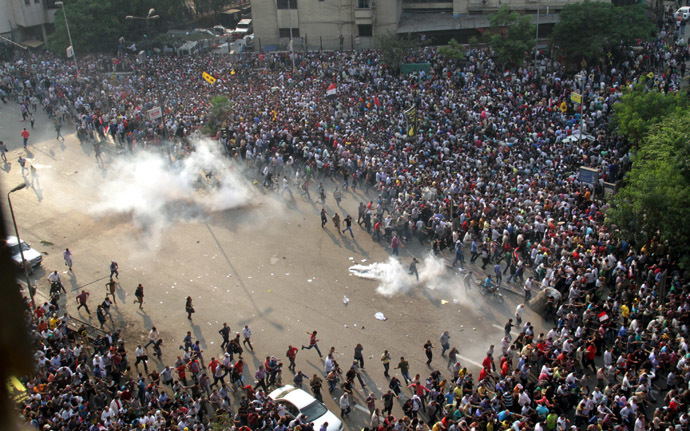 Egyptian Muslim brotherhood and supporters of ousted president Mohamed Morsi run for cover from tear gas during clashes with riot police along Ramsis street in downtown Cairo, on October 6, 2013. (AFP Photo)